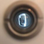 a close up of a toilet bowl with a reflection of a person in it